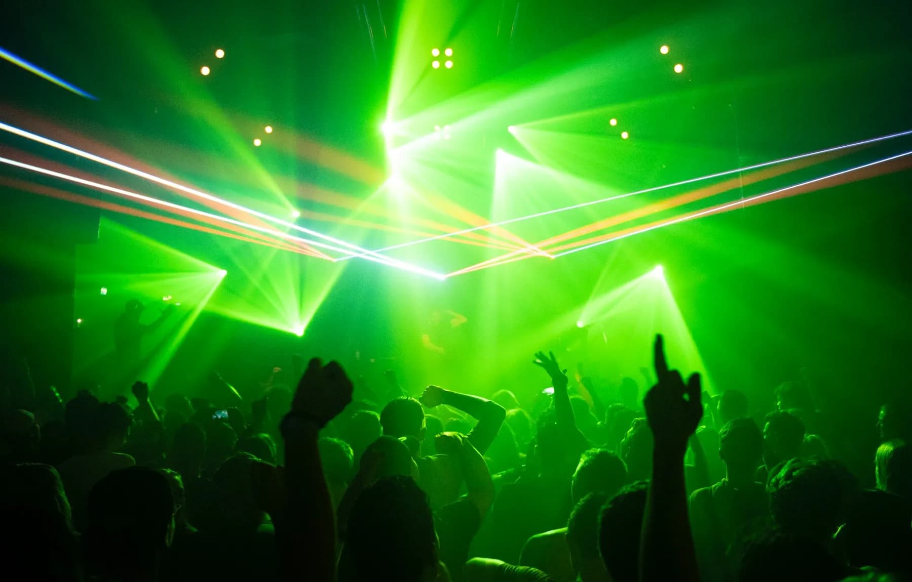 Publikum unter grünem Laserlicht in einem Club