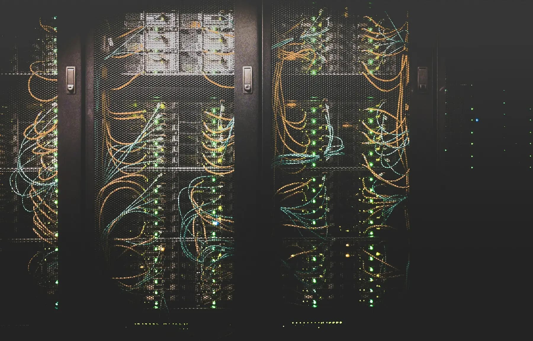 Serverschränke mit Netzwerkkabeln und grünen Statuslichtern in einem Rechenzentrum